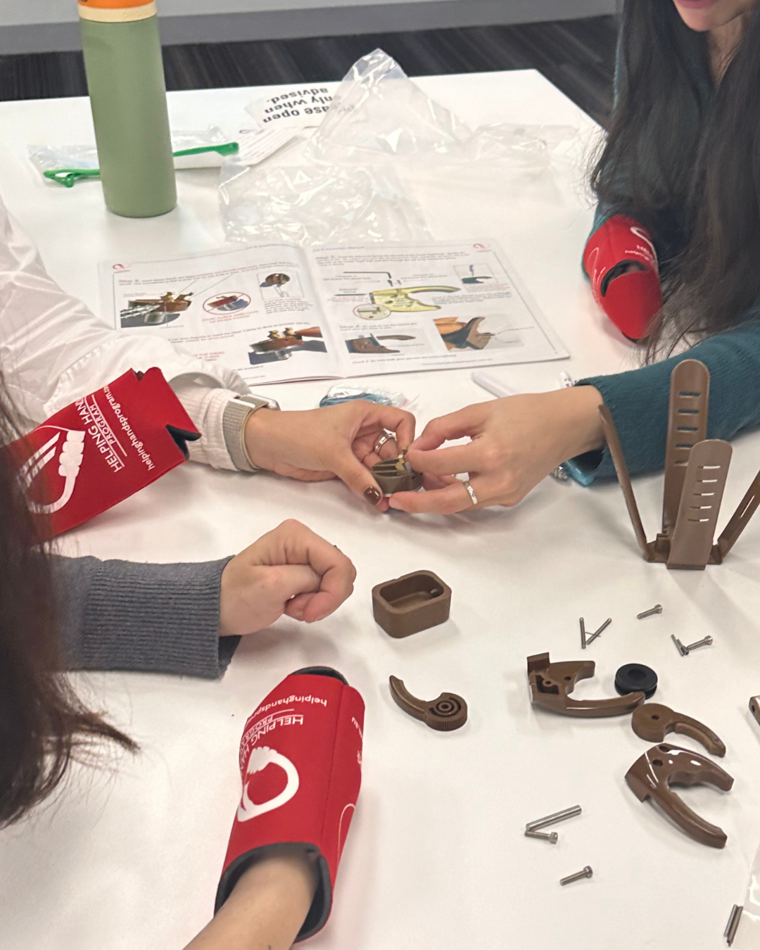 CPBS team members collaborating to assemble prosthetic hands during the Helping Hands team building activity
